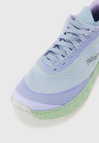 Scarpa da corsa leggera in blu pastello e viola con tomaia in rete testurizzata, suola verde e lacci a contrasto, con design aerodinamico.