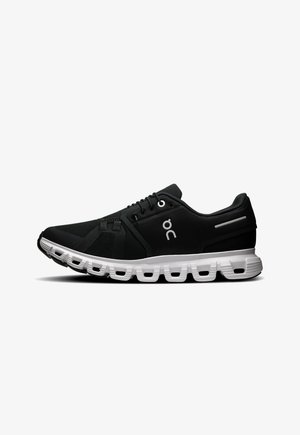 Schwarzer Sportschuh mit einem Mesh-Obermaterial, weißer gepolsterter Sohle, geschwungenem Design und leicht strukturierten Akzenten. Auf der Seite befindet sich ein Logo.