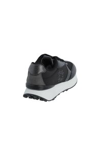 Zapatilla negra con parte superior de cuero suave, acentos texturizados en gris y una mediasuela blanca. Incluye una suela de goma con surcos de tracción.