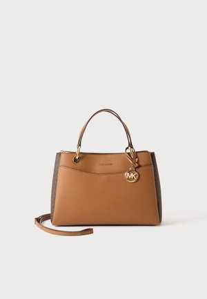 Braune Michael Kors Handtasche mit Doppelgriffen, goldfarbenem Logo-Anhänger und abnehmbarem Schulterriemen auf einfarbigem Hintergrund.