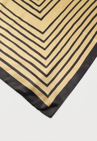 Μεταξωτό μαντήλι με μαύρες και χρυσές διαγώνιες ρίγες που σχηματίζουν σχέδιο ζικ-ζακ, εμφανίζεται επίπεδο σε λευκή επιφάνεια.