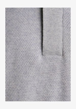 Szary dzianinowy materiał z fakturowanym, plasterkowym wzorem oraz gładkim, jednolitym kołnierzem. Materiał wydaje się miękki i lekki.