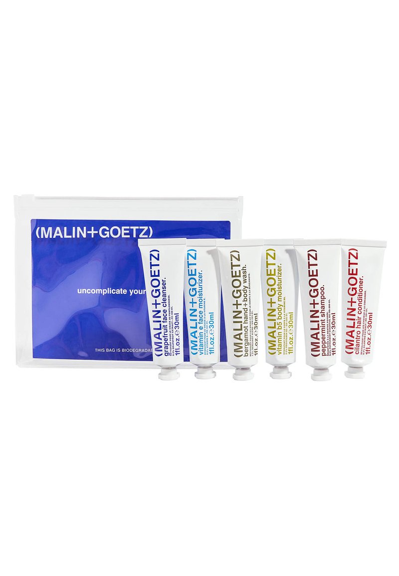 Fünf weiße Tuben mit Hautpflegeprodukten, die farbige Etiketten in Blau, Gelb, Rot und Grün haben, verpackt in einer klaren Tasche mit einem blauen Design.