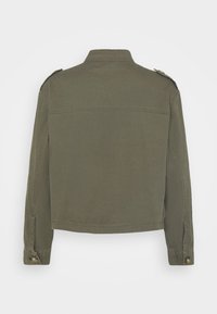 Veste courte vert olive avec manches longues, épaulettes et poignets boutonnés, vue de dos sur un fond uni.
