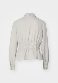 Blusa a maniche lunghe grigia chiara con colletto, vita elasticizzata e tessuto arricciato. Texture liscia e dettagli con bottoni sulle maniche.