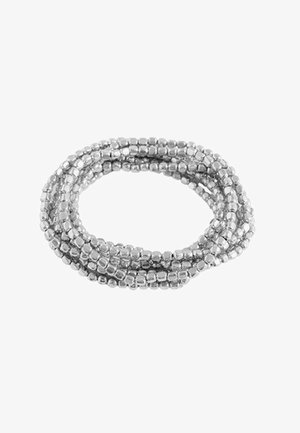 Bracelet multi-brins en perles d'argent avec de petites perles brillantes de forme carrée, étroitement liées entre elles en boucle.
