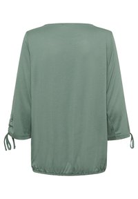 Green blouse with 3/4 sleeves, rounded neckline, and drawstring accents at sleeve cuffs. Made of soft, smooth fabric with a slightly relaxed fit.