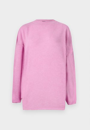Pull en rose en tissu doux, avec une coupe loose, un col rond, des manches longues et des fentes sur les côtés à l'ourlet.
