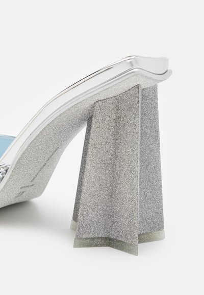 Escarpin argenté avec une texture pailletée et un talon carré au design unique. Présente un bord métallique brillant et une semelle intérieure bleu clair.