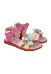 Sandalias rosas y amarillas con un patrón de lunares y lazos grandes. Cuenta con correas ajustables y una suela de goma texturizada.
