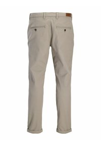 Beżowe bawełniane spodnie o prostym kroju, z podwiniętymi nogawkami, dwoma tylnymi kieszeniami zapinanymi na guziki oraz skórzanym akcentem w pasie.