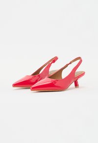 Pantofi cu toc slingback din piele lacuită roșie, cu vârf ascuțit și toc mic, gros. Textură netedă cu un design minimalist.