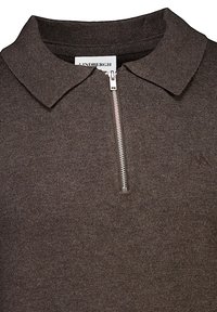 Brun dragkedja polo skjorta i en texturerad stickad kvalitet, med klassisk krage och diskret logobroderi nära fållen.