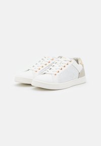 Vita sneakers med en slät syntetisk ovandel, med en texturerad silverfärgad sidopanel, gyllene öglor och en ljus gummisula.