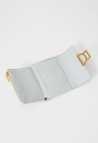 Portefeuille en cuir texturé bleu clair avec quincaillerie dorée. Comprend plusieurs emplacements pour cartes, un compartiment zippé et un accent distinctif de logo.