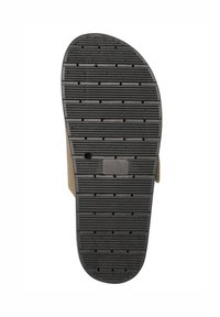 Tan sandal med en texturerad svart gummisula som har horisontella ränder och små hål för grepp, designad för komfort och hållbarhet.