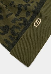 Olijfgroene gebreide beanie met een zwart luipaardpatroon, een getextureerde band en een goudkleurig logo-detail. Zacht, geribbeld materiaal.