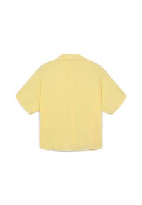 Camicia gialla a maniche corte con una vestibilità rilassata e colletto, mostrata da dietro su uno sfondo bianco uniforme.