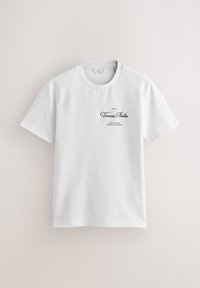 Fehér pamut póló kerek nyakkal. Elöl fekete szöveg: "Verona Italia, Provincia Veneto Region". Simább textúra.