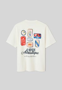 T-shirt blanc avec des illustrations colorées de sept designs de poissons en conserve et le texte "Côte Adriatique" listant les pays adriatiques en dessous.