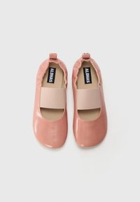 Rosa lackierte Ballerinas mit einem elastischen Kragen, einem breiten elastischen Riemen über dem Fuß und einer abgerundeten Zehenpartie.