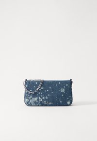 Sac en denim à bandoulière avec un motif éclaboussé, une chaîne argentée, une fermeture éclair et un logo en bas. Forme rectangulaire.