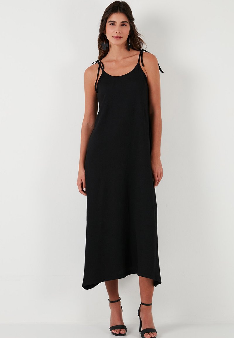 Schwarzes Maxikleid mit lässiger Passform, aus einem weichen Stoff gefertigt. Es hat dünne, verstellbare Träger und einen leicht asymmetrischen Saum.
