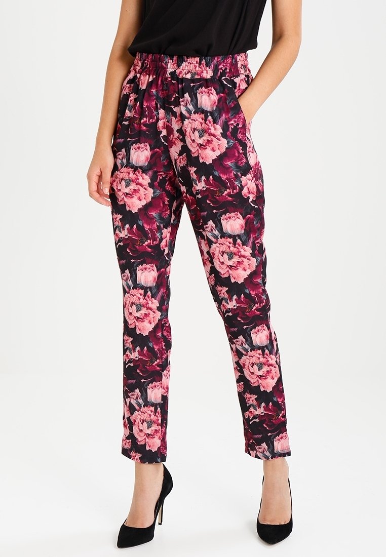 Bloemmotief broeken met een zwarte achtergrond en grote roze en witte bloemen, elastische tailleband en zijzakken.