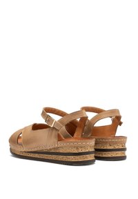 Jasnozłote sandały na platformie z otwartym palcami, z teksturowaną korkową podeszwą, regulowanym paskiem i wycięciami w górnej części dla lepszej wentylacji.