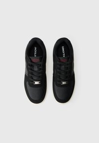 Pair of black Jack & Jones sneakers with laces and white soles, viewed from above on a white background.