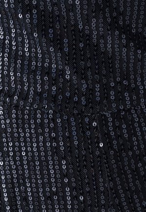 Tissu en sequins noirs avec une surface texturée. Les sequins sont de forme circulaire et réfléchissent la lumière, disposés en lignes verticales sur un matériau de support doux.