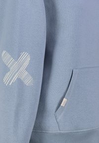 Lichtblauwe hoodie van zacht materiaal. Bevat een getextureerd wit X-logo op de linkermouw en een voorzak met hoekige details.