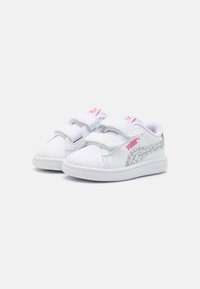 Sneakers bianchi con cinturini in velcro, dettagli argentati testurizzati e logo rosa. Materiale liscio e design a punta arrotondata. Suola in gomma.