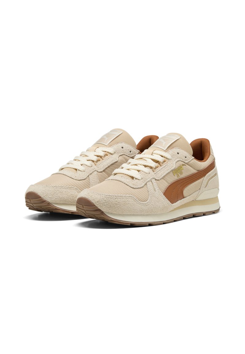 Ein Paar beiger und brauner Puma-Sneaker mit Wildleder- und Mesh-Details, die Schnürsenkel sind gebunden und die Schuhe sind schräg positioniert, um die Außenseiten auf einem weißen Hintergrund zu zeigen.