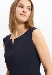 Navyblaue ärmellose Kleid mit einem V-förmigen Ausschnitt, glatter Textur und taillierter Passform, mit sichtbaren Nahtdetails und ohne Muster.