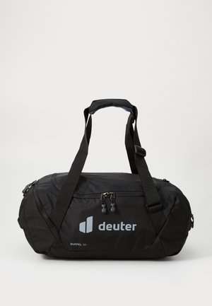 Borsa duffel nera realizzata in tessuto resistente, dotata di tasche con doppia zip, manico imbottito e logo; forma cilindrica con spallacci robusti.