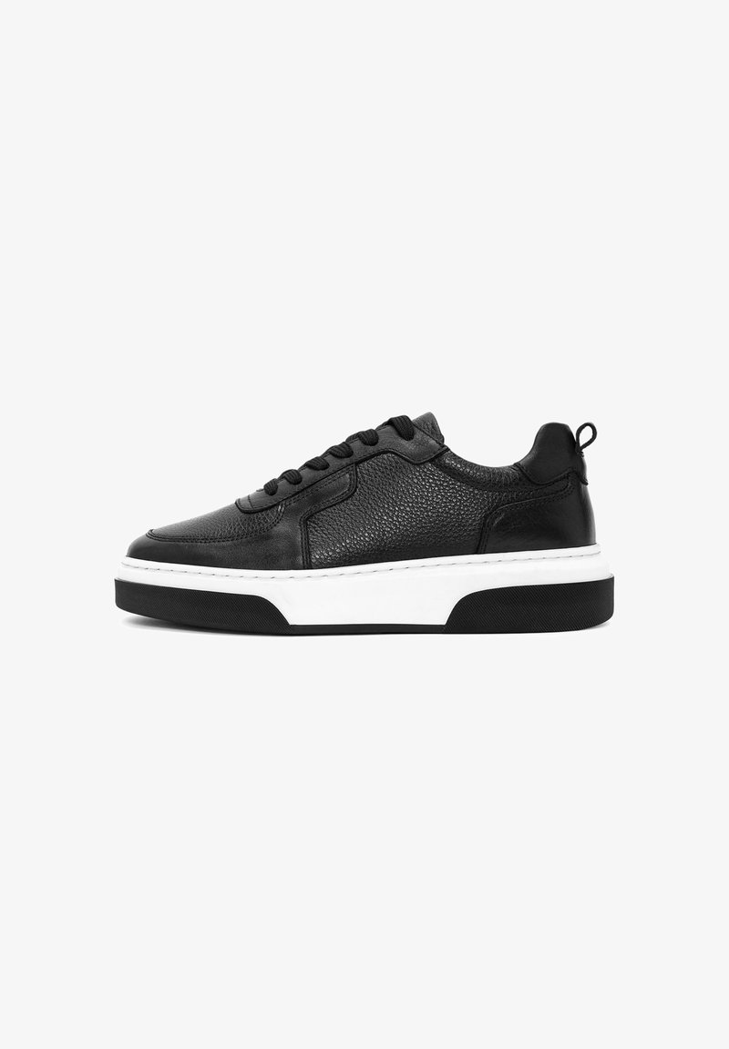 Baskets en cuir noir avec une tige texturée, semelle intermédiaire blanche et semelle extérieure en caoutchouc noir. Elles sont dotées de lacets ronds et d'un onglet au talon pour un meilleur accès.