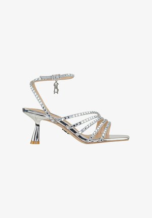 Sandali alti con tacco argentati con dettagli in strass, accenti metallici, tacco di altezza media e cinturino alla caviglia regolabile.