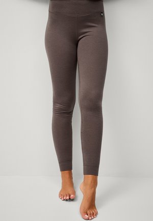 Brune leggings med en glat tekstur, høj talje og tapered ben. Har et lille logo nær taljen.