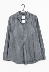 Gray long-sleeve shirt with a collared neckline, featuring a subtle textured pattern and a partial button placket, hung on a black hook.