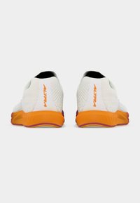 Ζευγάρι λευκών αθλητικών παπουτσιών από δίχτυ με πορτοκαλί σόλες, ορατά από πίσω, που δείχνουν το όνομα της μάρκας "ALTRA" σε πορτοκαλί στη φτέρνα.