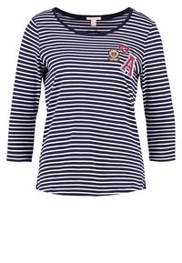 Marinblå och vit randig l ångärmad tröja med sömlös halsringning, med ett märke med ett "A" och broderade detaljer på vänster sida.