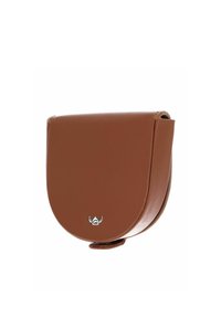 Sacoche de selle en cuir marron avec rabat arrondi et petit emblème argenté à l’avant, conçue pour un usage équestre ou décontracté.