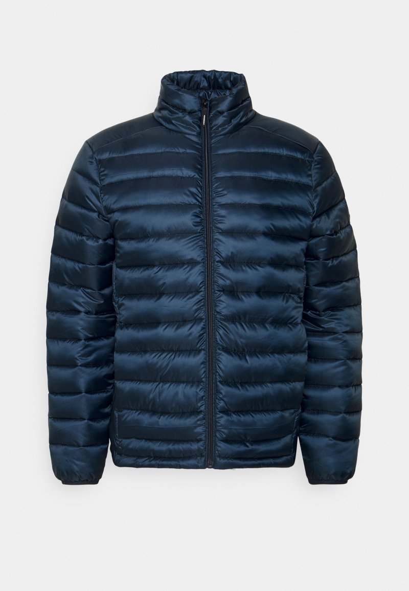 Marinblå puffer-jacka med kviltade vertikala paneler, hög krage och frontdragkedja. Slätt, glänsande och lätt material.