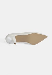 Weiße High-Heels mit spitzer Zehenpartie und glattem Lederobermaterial. Die Sohle ist beige mit einem leichten Glanz und einem kleinen Akzent an der Ferse.