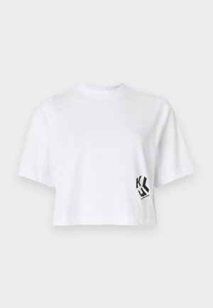 Witte cropped t-shirt van katoen met korte mouwen en een zwart logo-ontwerp aan de linkerkant. Eenvoudige ronde halslijn.