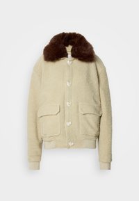 Beige bolyhos dzseki barna műszőrme gallérral, elöl gombos záródással és két zsebbekkel. Puha tapintású, laza stílusú.