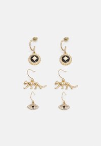 Brincos de ouro com um encanto circular apresentando um fundo preto e um design de folha, uma forma de leopardo e um encanto de olho com detalhes pretos.