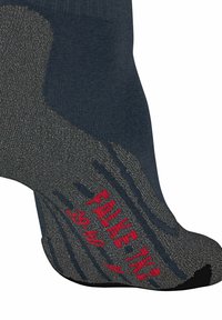 Marineblauer und grauer Socke mit strukturiertem Boden, der mit Grifffmustern und rotem "FALKE TK"-Text versehen ist. Leicht dehnbar und geeignet für aktive Kleidung.