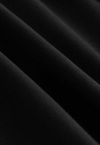 Tissu noir à texture lisse, délicatement plissé, avec un léger éclat et un motif de fines côtes. Matériau doux et extensible.